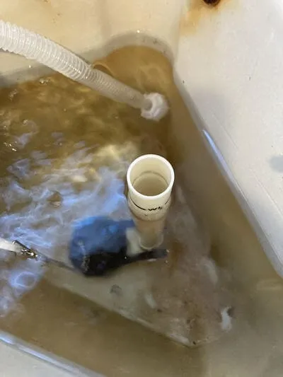 トイレタンク内部のオーバーフロー管を交換している作業